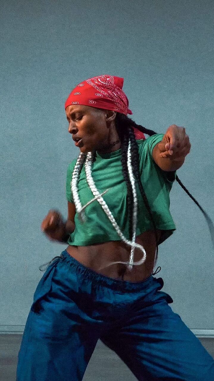 Woman in a green tee dancing in a studio
