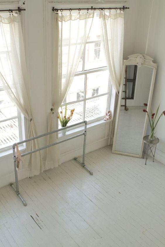 Sunlit white corner with barre and full-length mirror